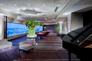 a hotel lobby with a piano and a room with couches at ANA Crowne Plaza Kanazawa by IHG in Kanazawa