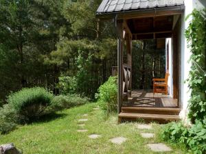 a porch of a cabin with a chair in a yard at Domek w Sosnowym Lesie in Sulicice