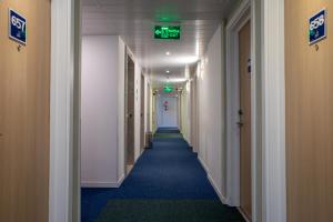 a long hallway with a green exit sign on the ceiling at ibis budget SP Frei Caneca in Sao Paulo