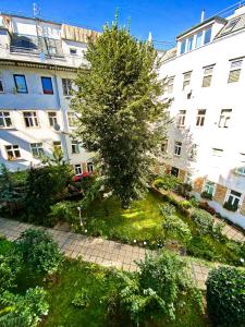 a tree in a courtyard in front of a building at Sweet Home Apartment in Vienna