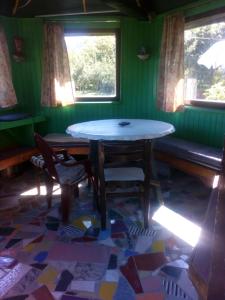 a table and chairs in a room with green walls at Vikend kuća Elmina Gorani VISOKO in Visoko