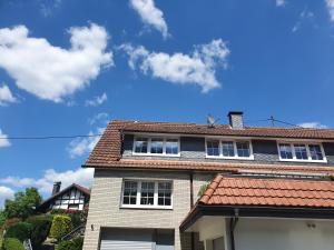uma casa com um telhado vermelho e um céu azul em Zwischen den Talsperren em Marienheide