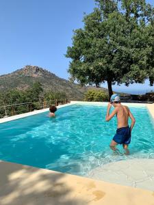 Ein Mann, der im Wasser im Pool steht. in der Unterkunft Casale Margherita Turismo Rurale in Pollina