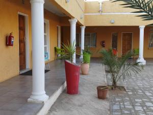 a courtyard with potted plants and a building with columns at Bonjour Inn Palapye in Palatswe