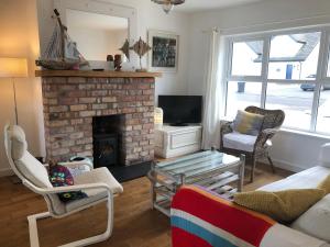 - un salon avec un canapé et une cheminée dans l'établissement Nanny Willow's Cottage, à Portballintrae