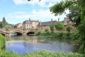 eine Brücke über einen Fluss mit Gebäuden im Hintergrund in der Unterkunft 1 The Cottage, Studio Apartment, Ye Olde Barn Apartments in Stamford