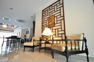 a living room with chairs and a lamp on a table at 906 Riverside Hotel Malacca in Malacca