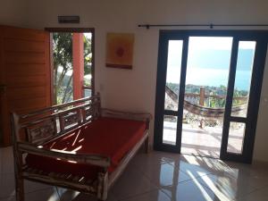 1 dormitorio con 1 cama y puerta corredera de cristal en Chale Por do Sol, en Ilhabela