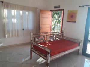 a bed in a room with a window and a door at Chale Por do Sol in Ilhabela