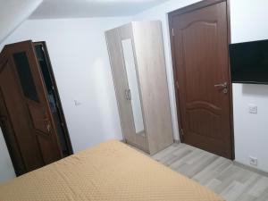 ein Schlafzimmer mit einem Bett, einem Spiegel und zwei Türen in der Unterkunft CASA TODEA in Câmpeni