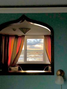 een spiegel in een kamer met uitzicht op de oceaan bij Pension & Spa de Watertoren in Zandvoort
