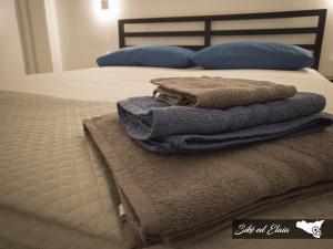 un mucchio di asciugamani seduti sopra un letto di Sikè ed Elaia a Ragusa
