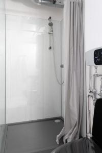 La salle de bains est pourvue d'une douche avec rideau. dans l'établissement Unique Tiny House getaway in the nature - Kenshó, à Puugi