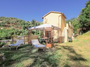 a small house with two chairs and an umbrella at Venus House in Lerici