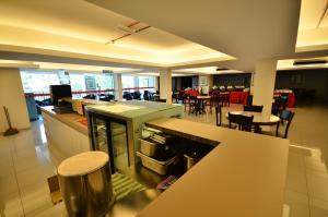 cocina grande y comedor con mesas y sillas en 906 Riverside Hotel Malacca, en Melaka