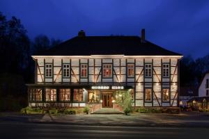 un gran edificio con luces encendidas por la noche en Hotel Grosse Klus, en Bückeburg