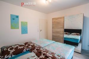 - une chambre avec un lit et un grand miroir dans l'établissement Comfort Apartment Oldenburg, à Oldenbourg