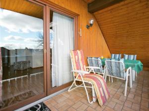 patio con mesa y sillas en el balcón en Spacious apartment near Lake Constance, en Ahausen