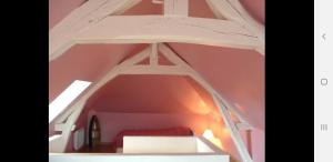an attic room with a bed in the middle at Gite Normandie in Forges-les-Eaux