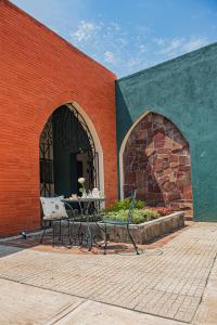 une table et des chaises devant un bâtiment en briques dans l'établissement Hotel Casa Real, à Villahermosa