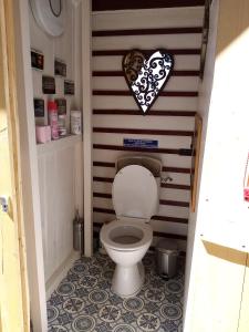 a toilet in a bathroom with a heart on the wall at Caravane Eriba au Bord de l'Eure in Neuilly