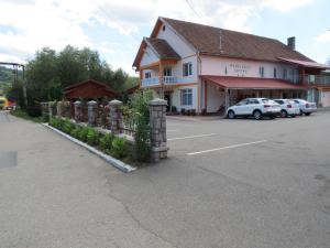 a building with cars parked in front of a parking lot at Pensiunea Cetina in Brad