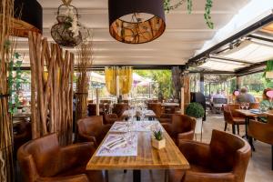 un restaurante con mesa de madera y sillas en Hotel Restaurant Bellevue, en Bormes-les-Mimosas