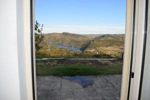 d'une porte coulissante en verre offrant une vue sur la montagne. dans l'établissement Douro Natura, à Bemposta