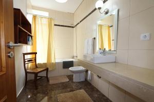 a bathroom with a sink and a toilet and a mirror at Quinta do Serrado in Porto Moniz