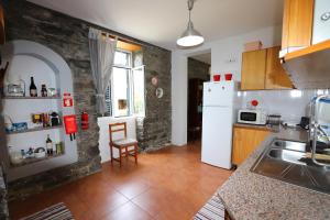 a kitchen with a sink and a white refrigerator at Quinta do Serrado in Porto Moniz