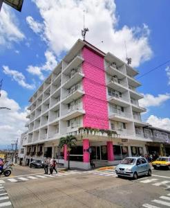 a large building with pink paint on the side of it at Hotel Palacio in C&oacute;rdoba