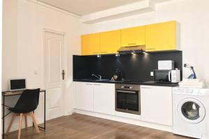 a kitchen with yellow cabinets and a washing machine at Luxury-Centre-Ville -Gare-netflix Wifi in Niort
