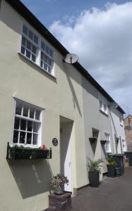 Una casa blanca con una ventana y flores. en Chapel Cottage, en Oundle