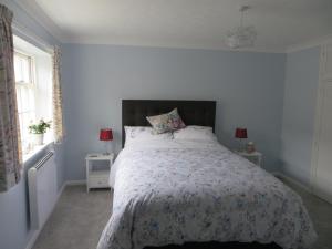 a bedroom with a large bed with a floral bedspread at Chapel Cottage in Oundle