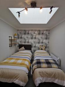two beds sitting next to each other in a bedroom at Chapel Cottage in Oundle