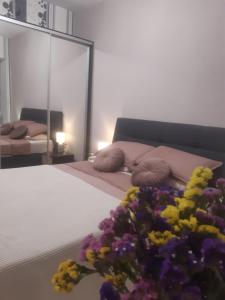 Schlafzimmer mit einem Bett mit einem Blumenstrauß in der Unterkunft London Apartment, Odessa in Odessa