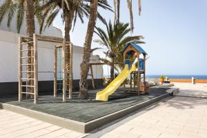 plac zabaw ze zjeżdżalnią i palmami na plaży w obiekcie AMAZING SEASIGHTS - TENERIFE w mieście Costa Del Silencio