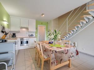 ヴィムルーにあるCosy holiday home with garden in Wimereuxのキッチン、ダイニングルーム(テーブル、椅子付)