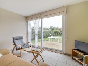 a living room with a couch and a television and a table at Cosy holiday home with garden in Wimereux in Wimereux