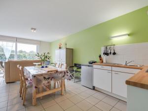 a kitchen with a table and a kitchen with green walls at Cosy holiday home with garden in Wimereux in Wimereux