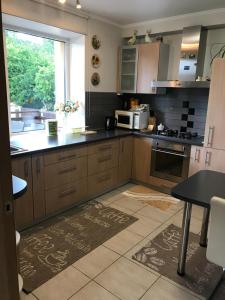 a kitchen with wooden cabinets and a table and a window at House on the sea side in Ragaciems