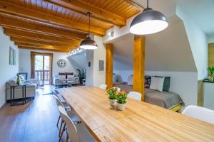 a dining room and living room with a wooden table and chairs at Pod Miloňovou in Velké Karlovice