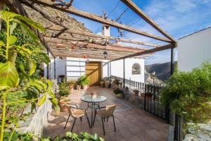 a patio with a table and chairs on a building at Casas Rurales Picachico in Laroya