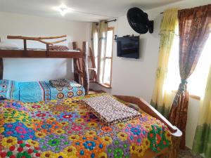 a bedroom with a bed covered in a colorful blanket at Apartamento Campestre Medellin in Medellín