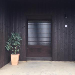 淡路kotobukian 寿庵的木门,前面有植物