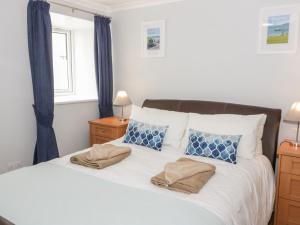 a bedroom with a white bed with blue curtains at Saron Chapel in Llandudno