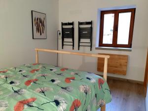 a bedroom with a bed with a flowered comforter at CASAS BEM HAJA Casa da Praça in São Miguel de Acha