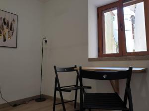 a table and a chair in a room with a window at CASAS BEM HAJA Casa da Praça in São Miguel de Acha +5 photos