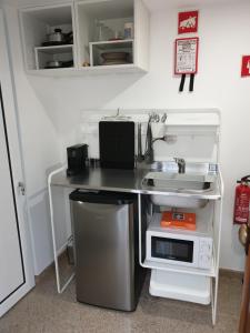 a kitchen counter with a sink and a microwave at CASAS BEM HAJA Casa da Praça in São Miguel de Acha