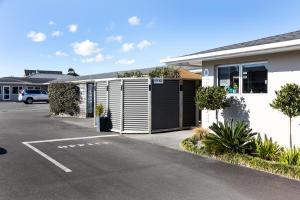 a building with a parking lot in front of it at Beach Street Motel Apartments in New Plymouth